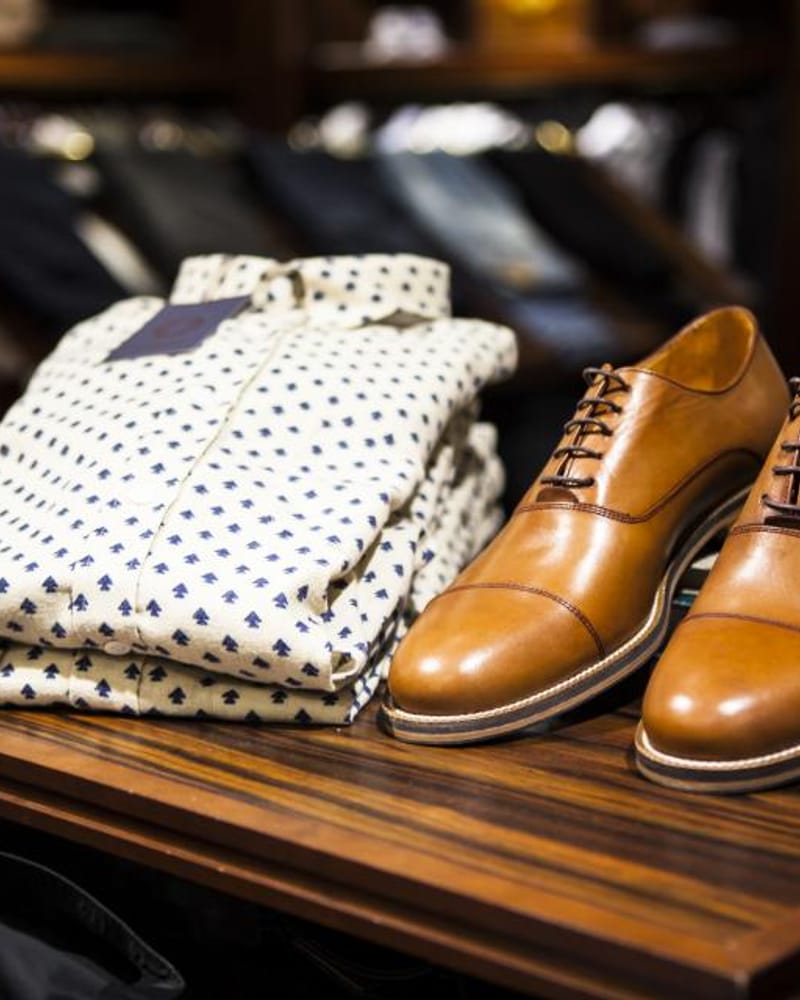 Zapatos Oxford marrones sobre camisas dobladas