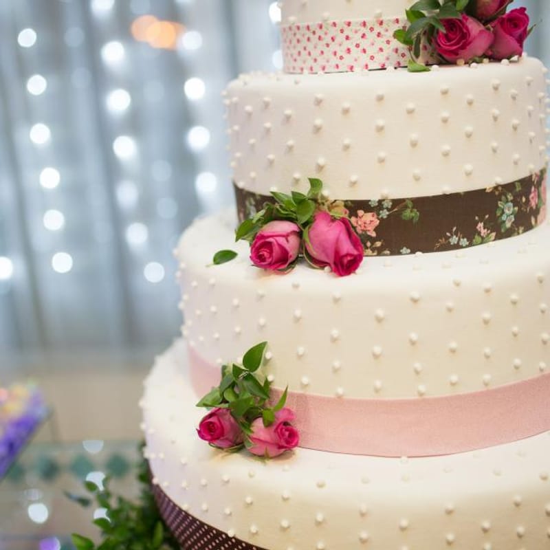 Pastel blanco de tres pisos con rosas